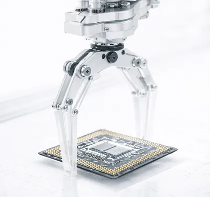 Roboterarm greift einen Computerchip auf einer technischen Oberfläche.