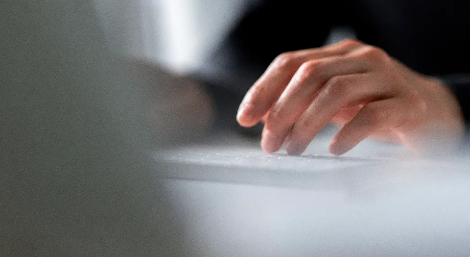 Nahaufnahme einer Hand auf einer Laptop-Tastatur.