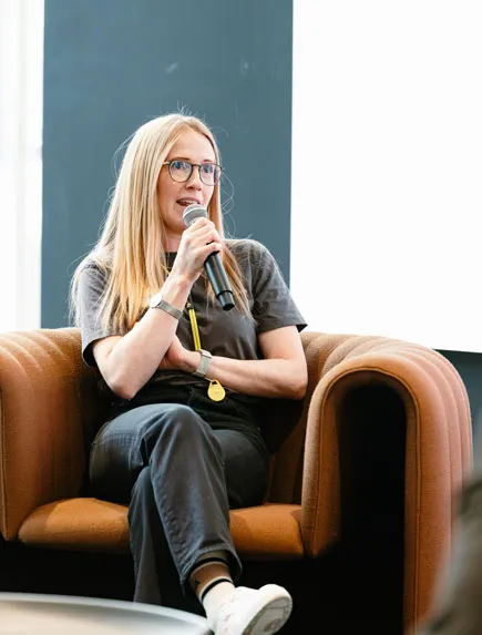 Teilnehmerin applaudiert während einer Präsentation bei einem Team-Event.