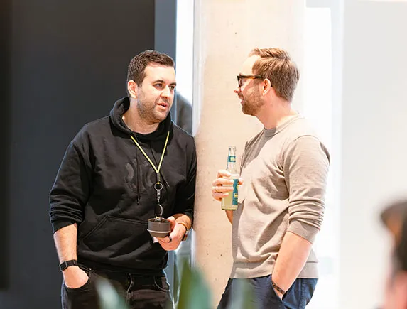 Mehrere Teilnehmende sitzen nebeneinander und hören aufmerksam einer Präsentation zu.