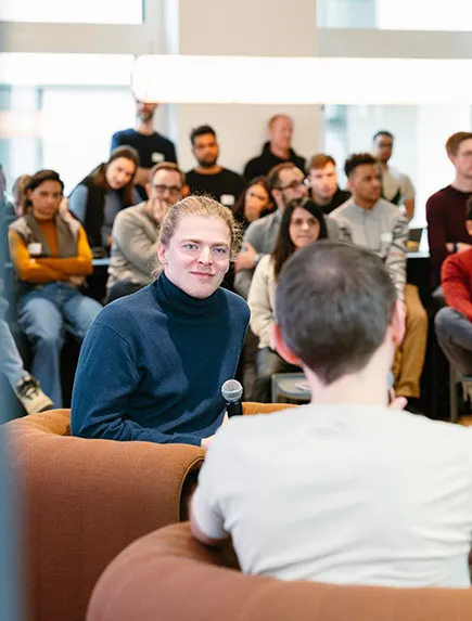 Reto Spörri und Yasser Jadidi lachen und unterhalten sich in einer Gruppe.