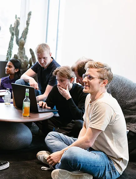 Kleine Gruppe arbeitet gemeinsam an Laptops während eines Workshops bei einem Team-Event.