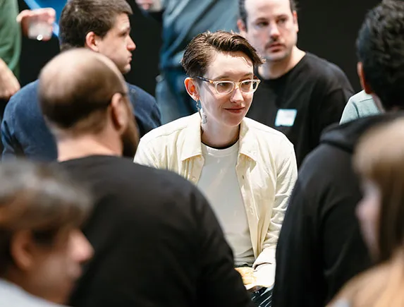 Teilnehmende sitzen in einer Gruppe und führen eine Diskussion während eines Team-Events.